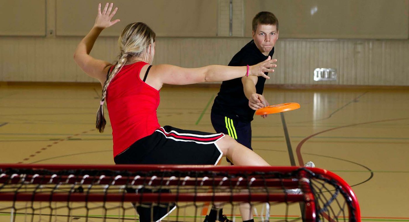 Zwei Jugendliche beim Frisbee auf ein Unihockey-Tor.