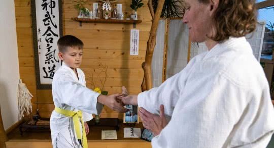 Schüler und Lehrperson beim Üben eines Aikido-Griffs.