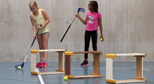 Zwei Màdchen beim Minigolfen in der Turnhalle