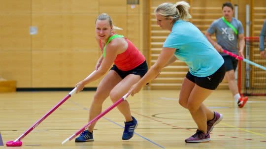 Frauen und Männer beim Donut-Hockey-Spielen.