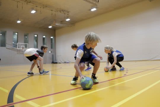 Dei bambini giocano con delle palle in cerchio
