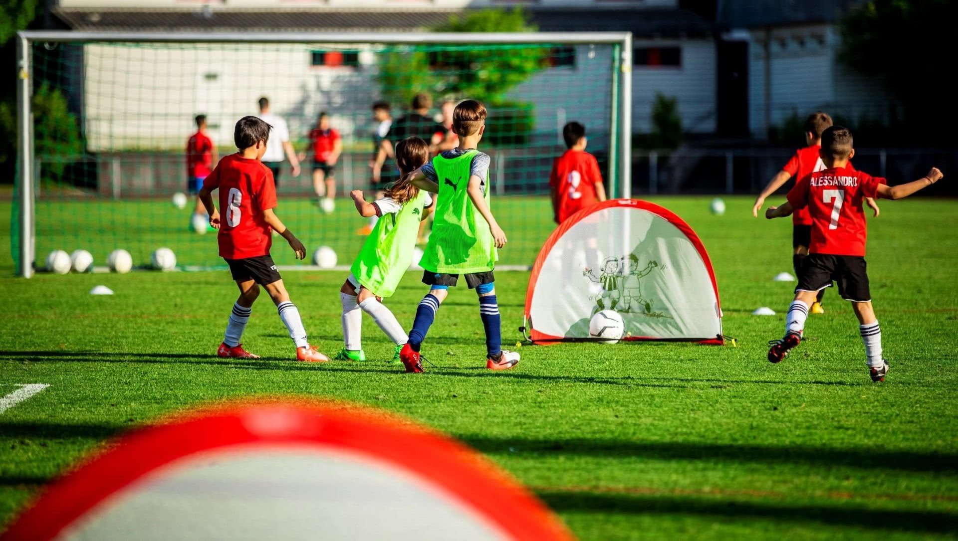 Des enfants jouent sur un petit terrain de football.