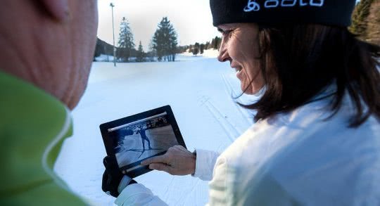 Due persone su una pista di sci di fondo consultano la App