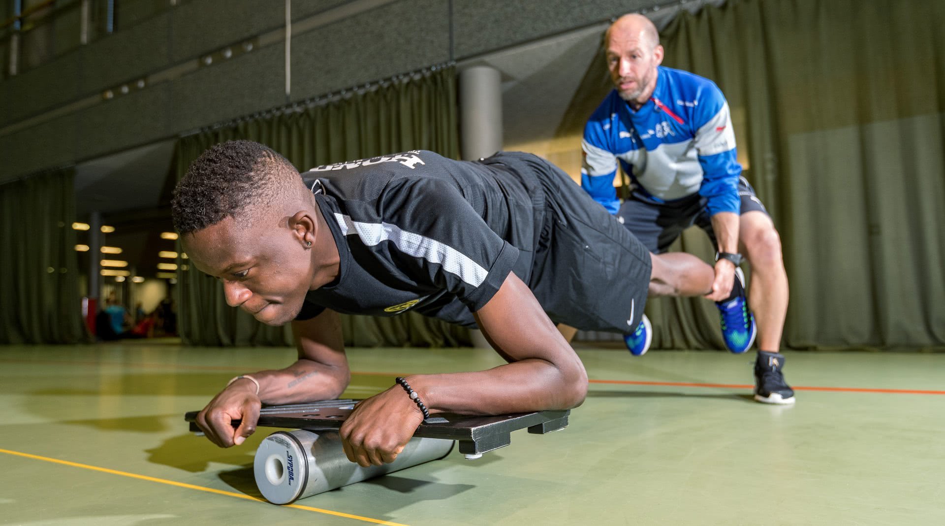 Phyisotherapeut mit Athlet beim Reha-Training.,