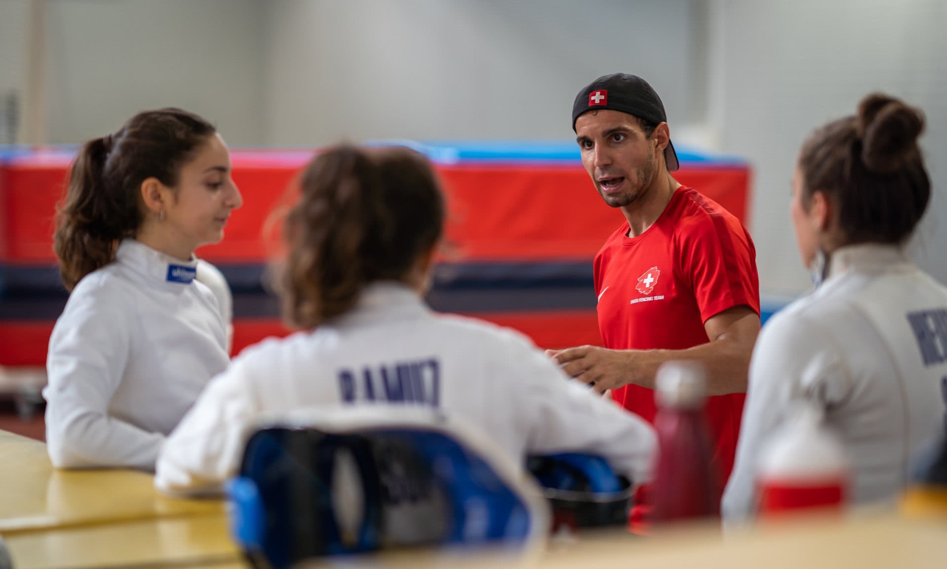 Ein Trainer beim Diskutieren mit Athletinnen.