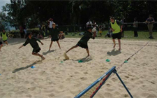 Situazine di gioco sulla spiaggia. Un bambino afferra una palla mentre un altro inizia a correre.