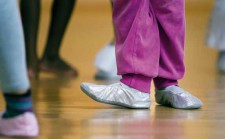 Un bambino con le sue scarpe da ballo.