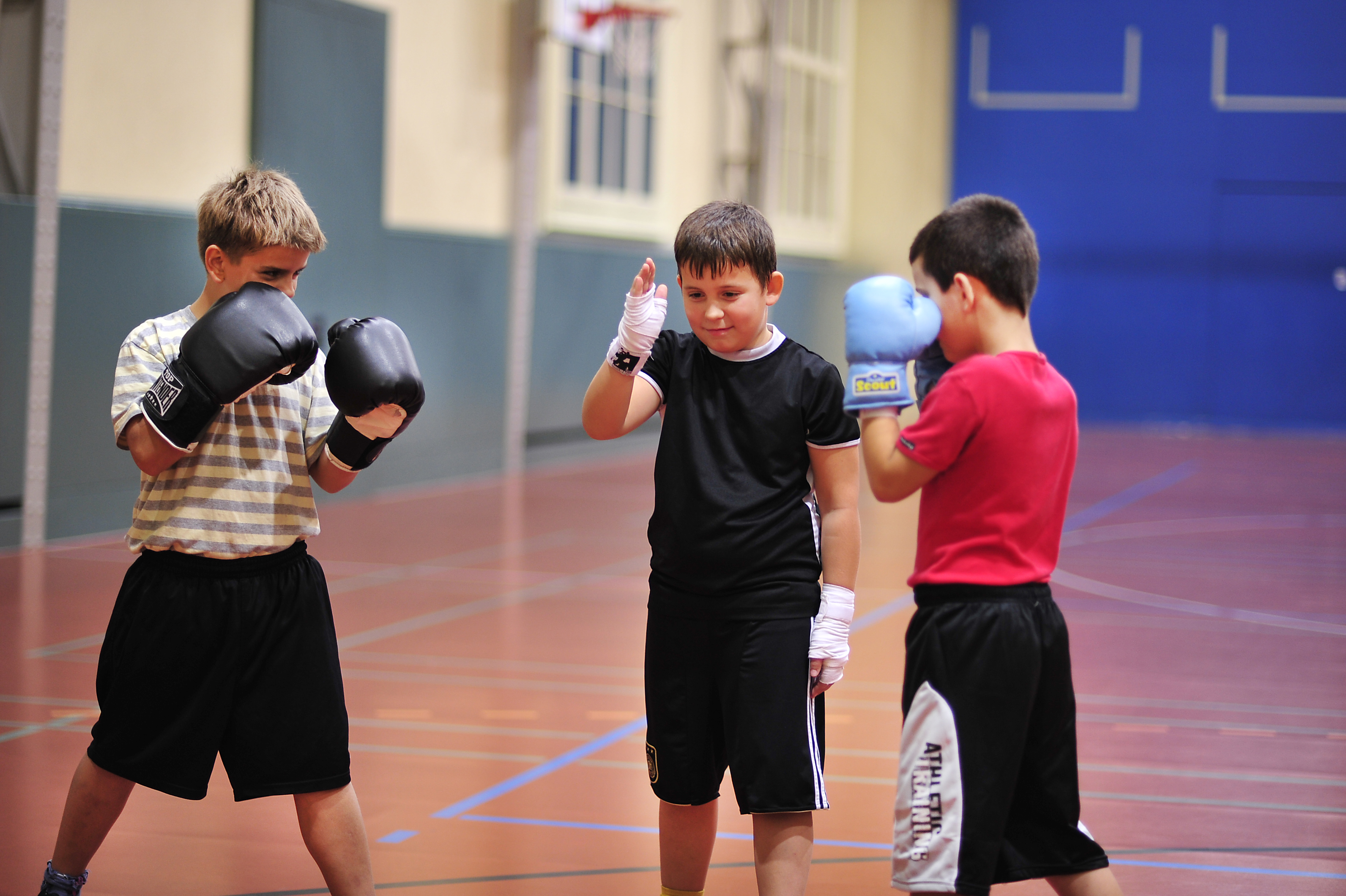 Deux boxeurs s'apprêtent à combattre sous la direction d'un camarade.
