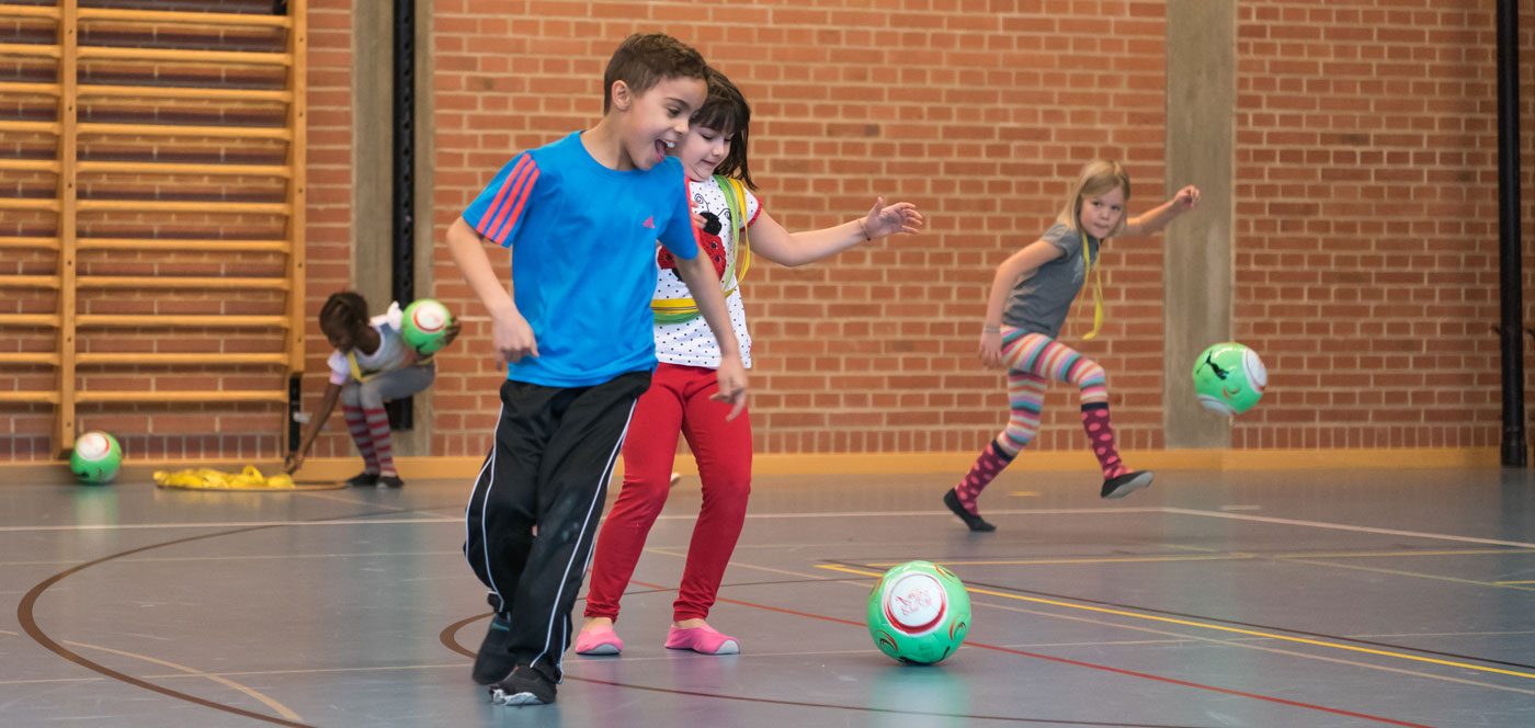 Monatsthema 05/2016: Fussball in der Schule - Titelbild: 3 Kinder beim Fussballspiel.