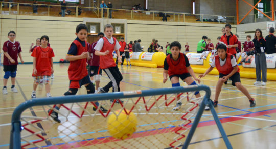 Des enfants sont en position de défense pour attraper le ballon.