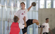 Handball: Rückraum Spieler beim Abwurf über einen Verteidiger.